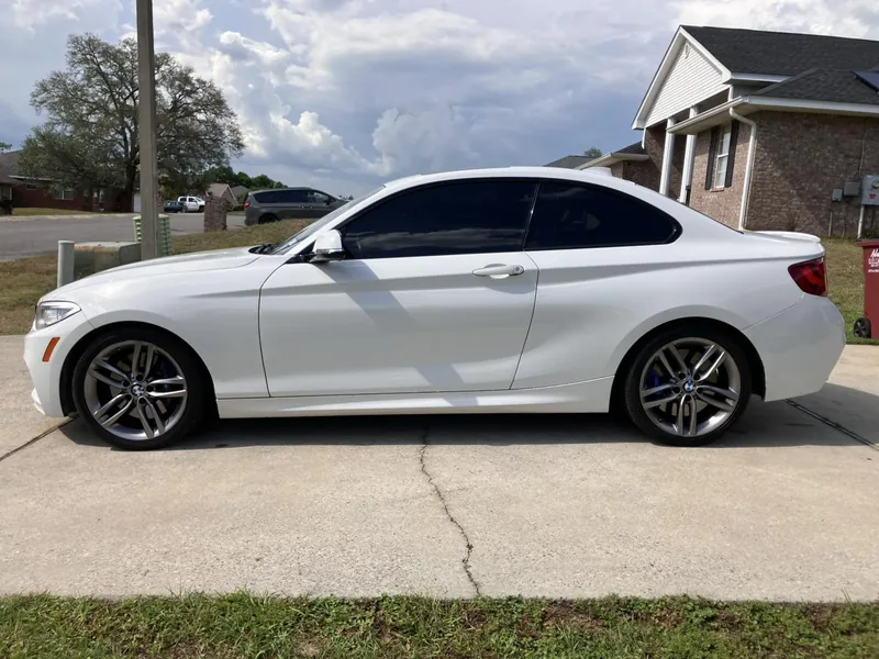White BMW 2 Series coupe with dark tinted windows — a job by RJ’s Tint Shop in Crestview, FL